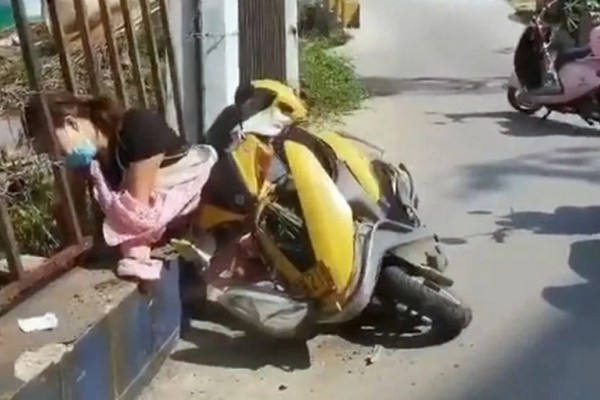 В Китае женщина упала со скутера и застряла головой в заборе. ФОТО